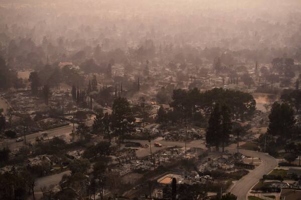 Smoke lingers over a neighborhood devastated by the Eaton Fire, Jan. 9, 2025, in Altadena, Calif. (AP Photo/John Locher, File)