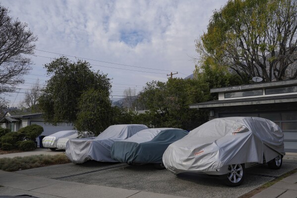 Covered vehicles are seen in Duarte, Calif., Friday, Jan. 31, 2025. (AP Photo/Damian Dovarganes)